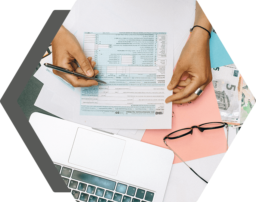 A person is holding a pair of scissors over an irs form.