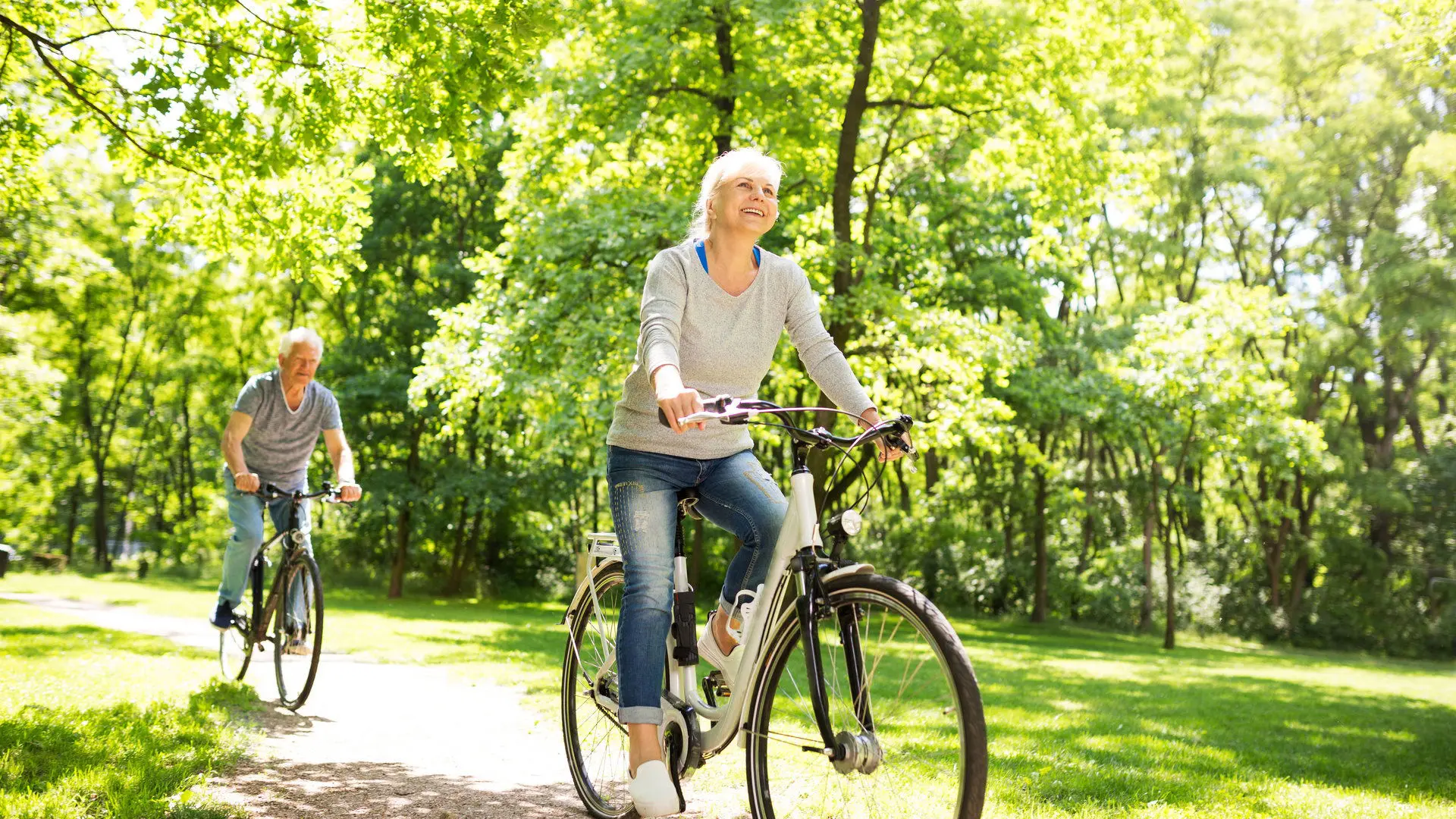 Senior Couple Riding Bikes In Park